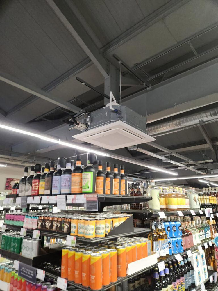 Ceiling cassette air conditioning on a UK retail shop floor.